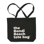 Black tote bag with 'the Bondi Beach tote bag' text on a white background
