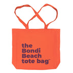 Orange tote bag with 'the Bondi Beach tote bag' text in purple