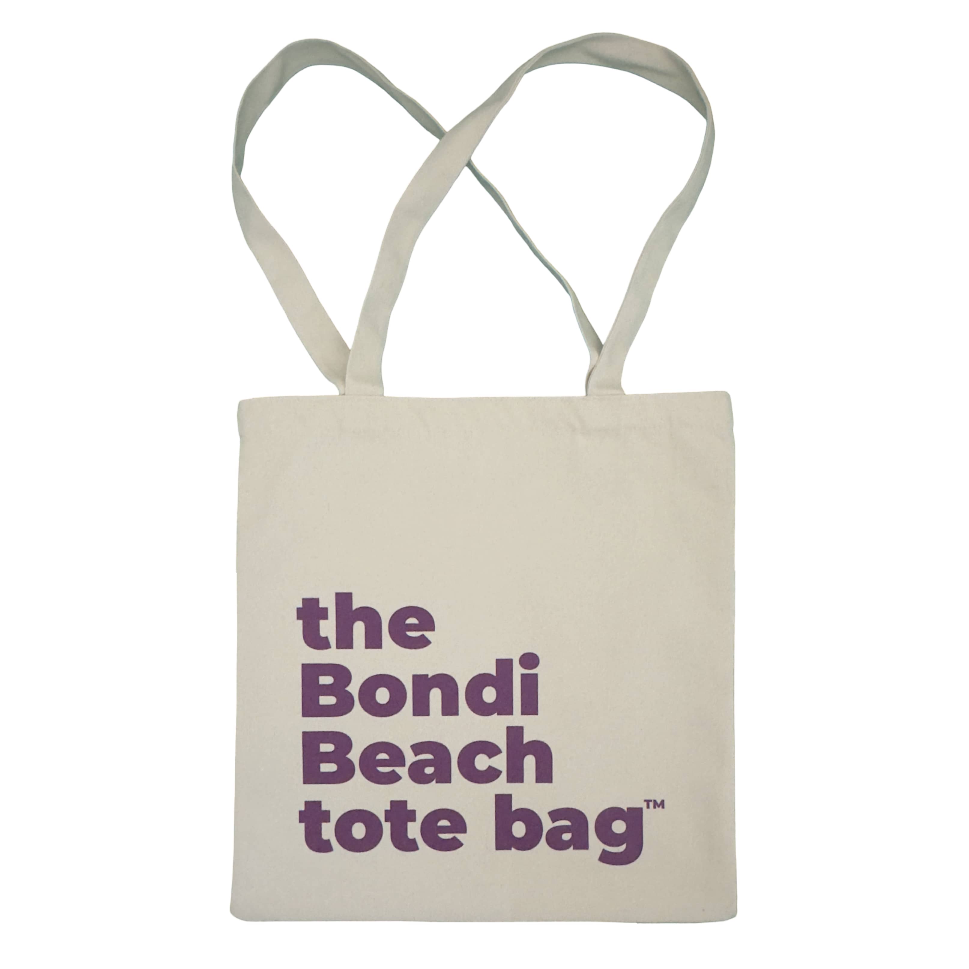 Beige tote bag with purple text 'the Bondi Beach tote bag' on a white background
