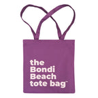 Purple tote bag with 'the Bondi Beach tote bag' text in soft pink