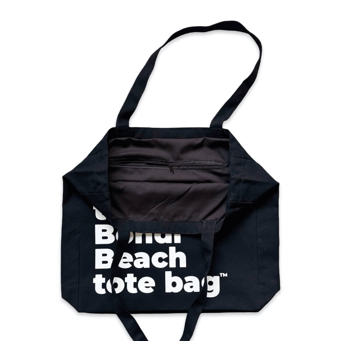 The Bondi Beach tote bag Big Bondi in black with white print open showing zip pocket and lining