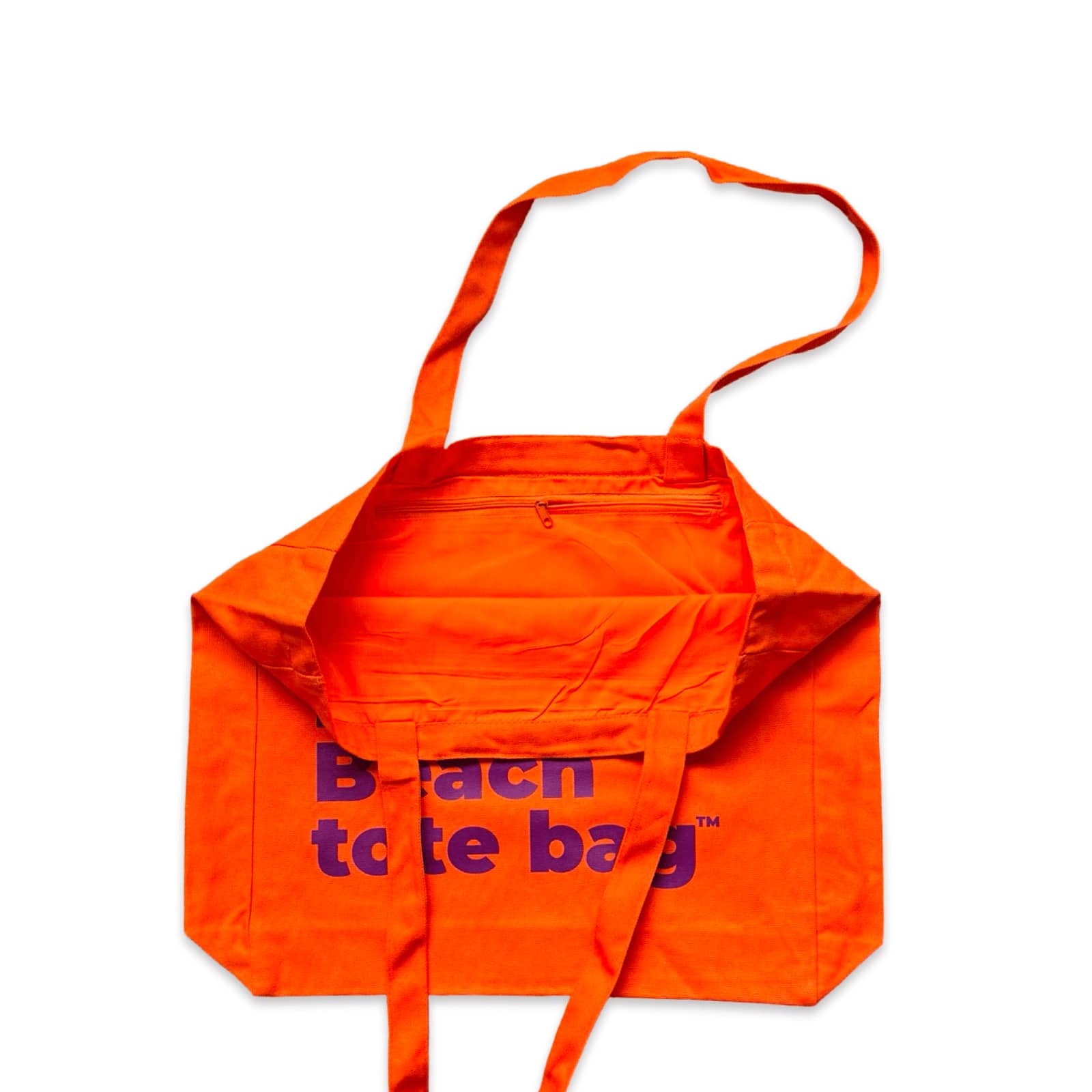 The Bondi Beach tote bag Big Bondi in orange with deep purple print open showing zip pocket and lining