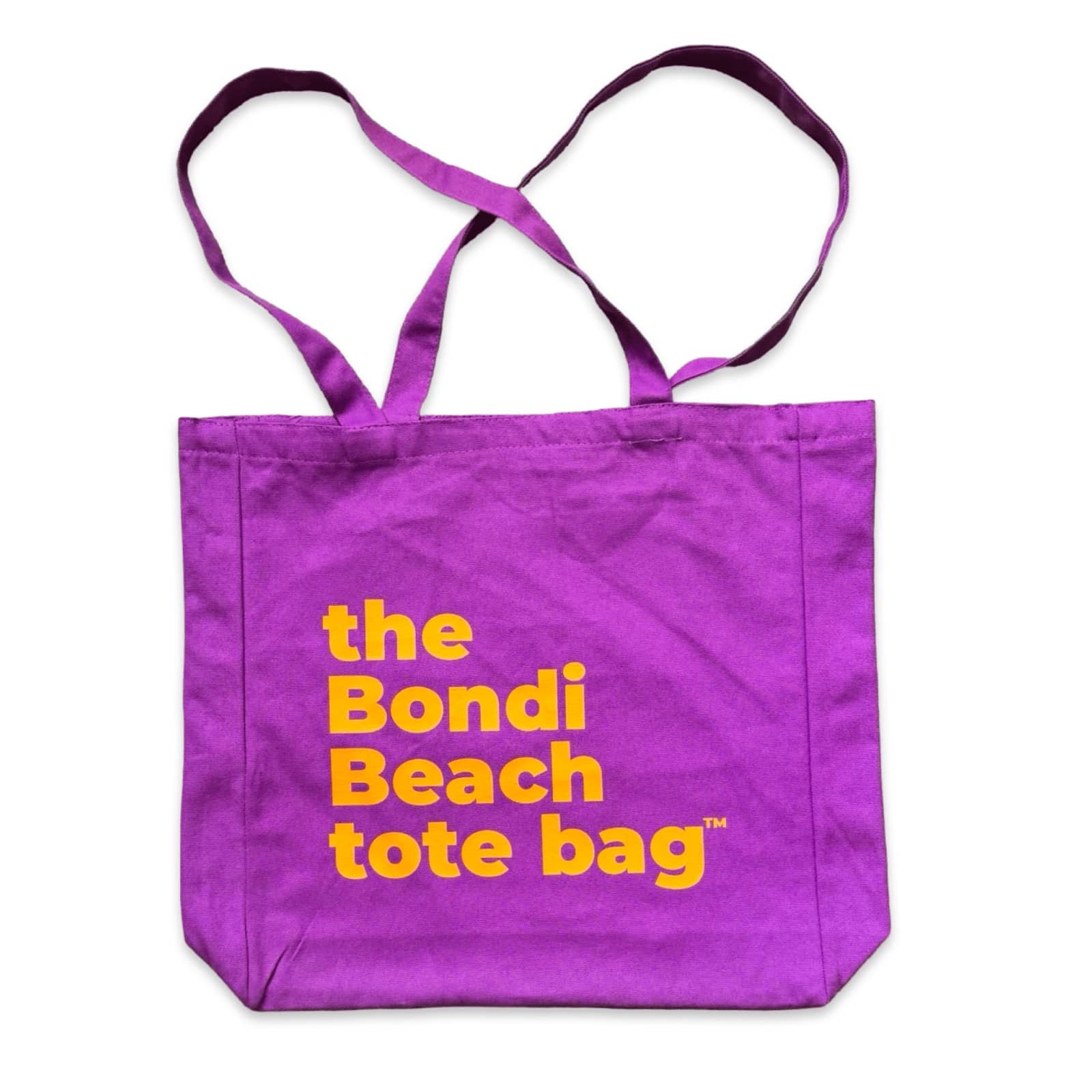 The Bondi Beach tote bag Big Bondi in purple with orange print flatlay closed showing roomy canvas structure