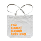 The Bondi Beach tote bag Big Bondi in off white with peach orange print flatlay closed showing roomy canvas structure