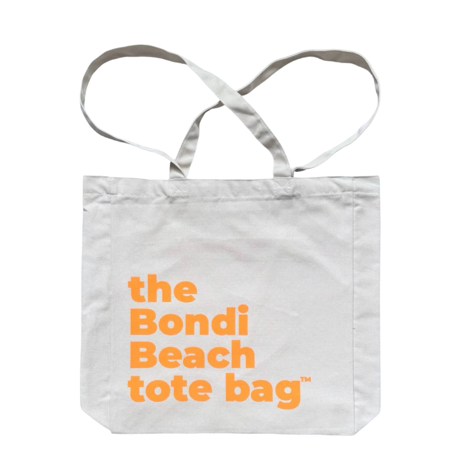 The Bondi Beach tote bag Big Bondi in off white with peach orange print flatlay closed showing roomy canvas structure