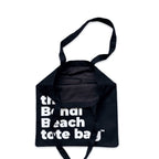 The Bondi Beach tote bag Little Bondi in black with white print open showing zip pocket and lining