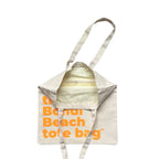 The Bondi Beach tote bag Little Bondi in off white with orange print open showing zip pocket and lining